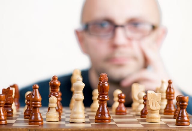 man playing chess pondering next strategic move